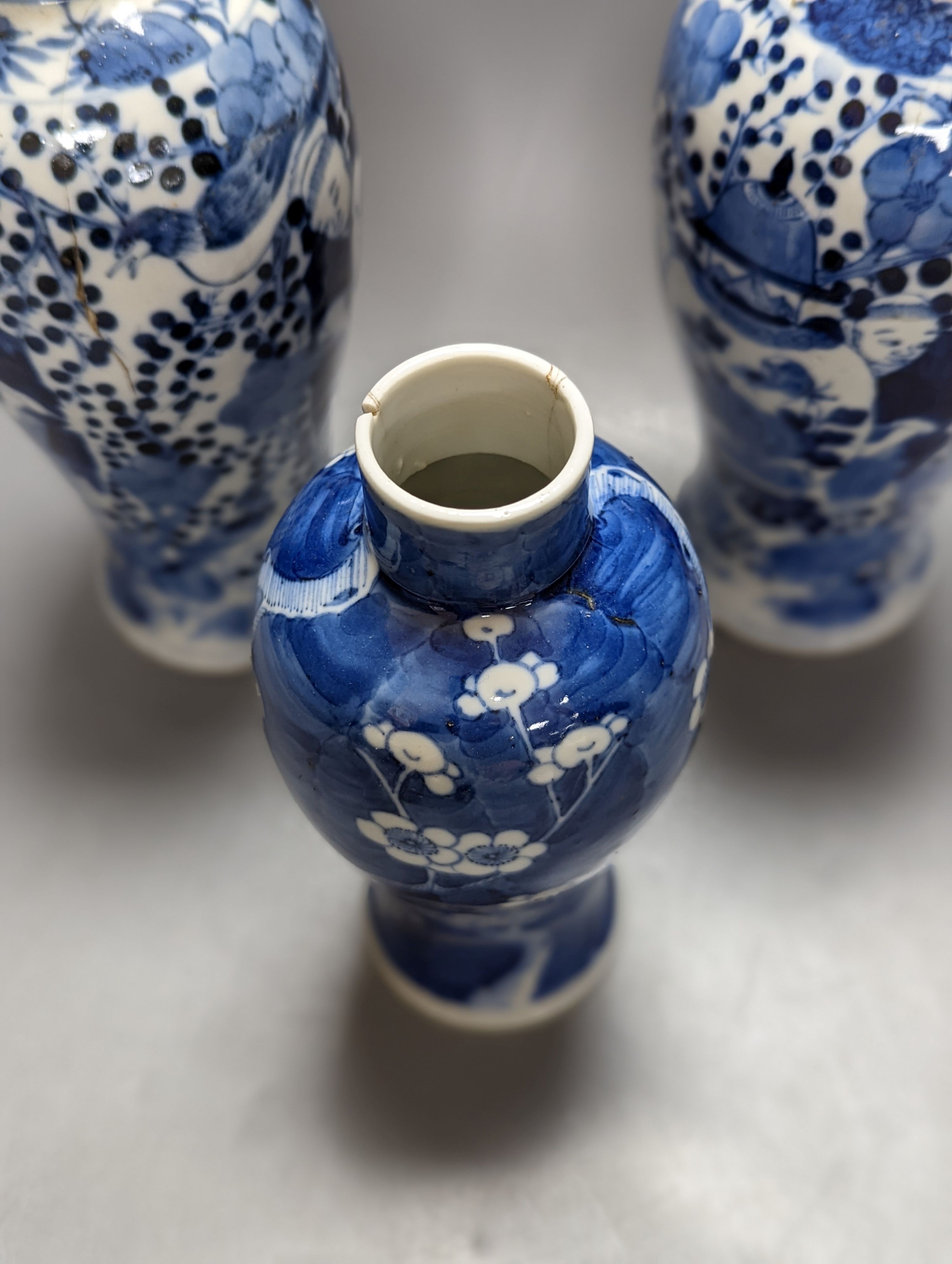 A pair of 19th century Chinese blue and white vases, a prunus vase and cover and a similar jar (4), pair of vases 24 cms high.